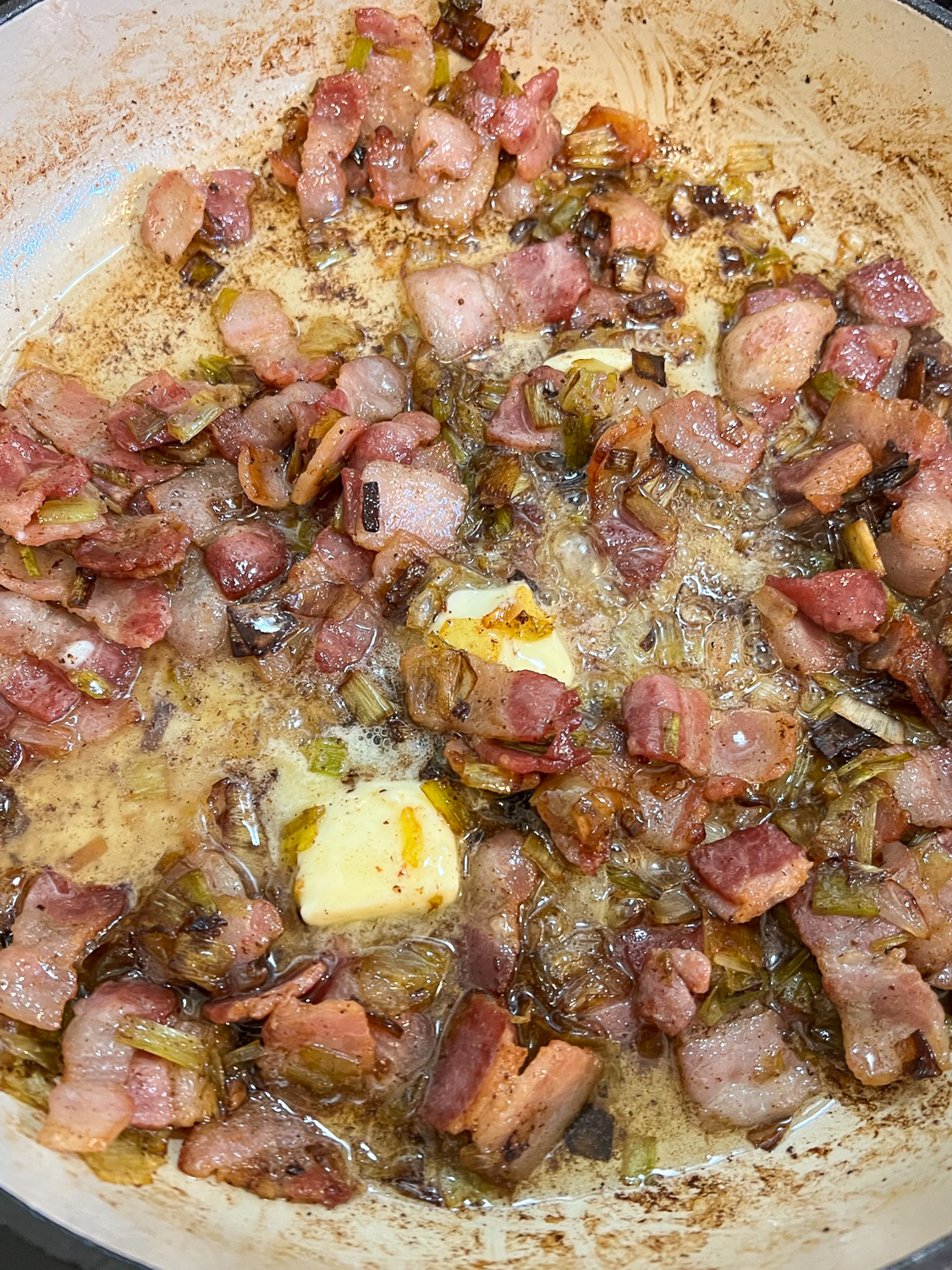 Butter added to the cooked bacon and leeks in the Dutch oven.