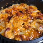 Top view of cheesy potatoes in a dutch oven.