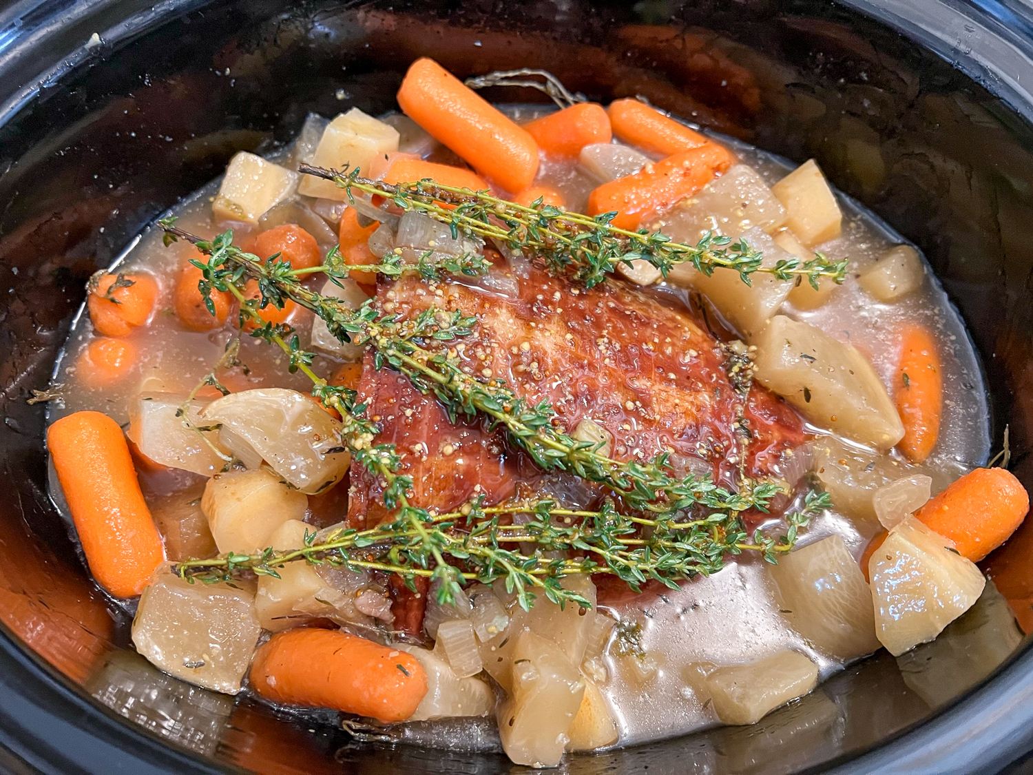 Ham, broth, vegetables, and glaze added to the slow cooker.