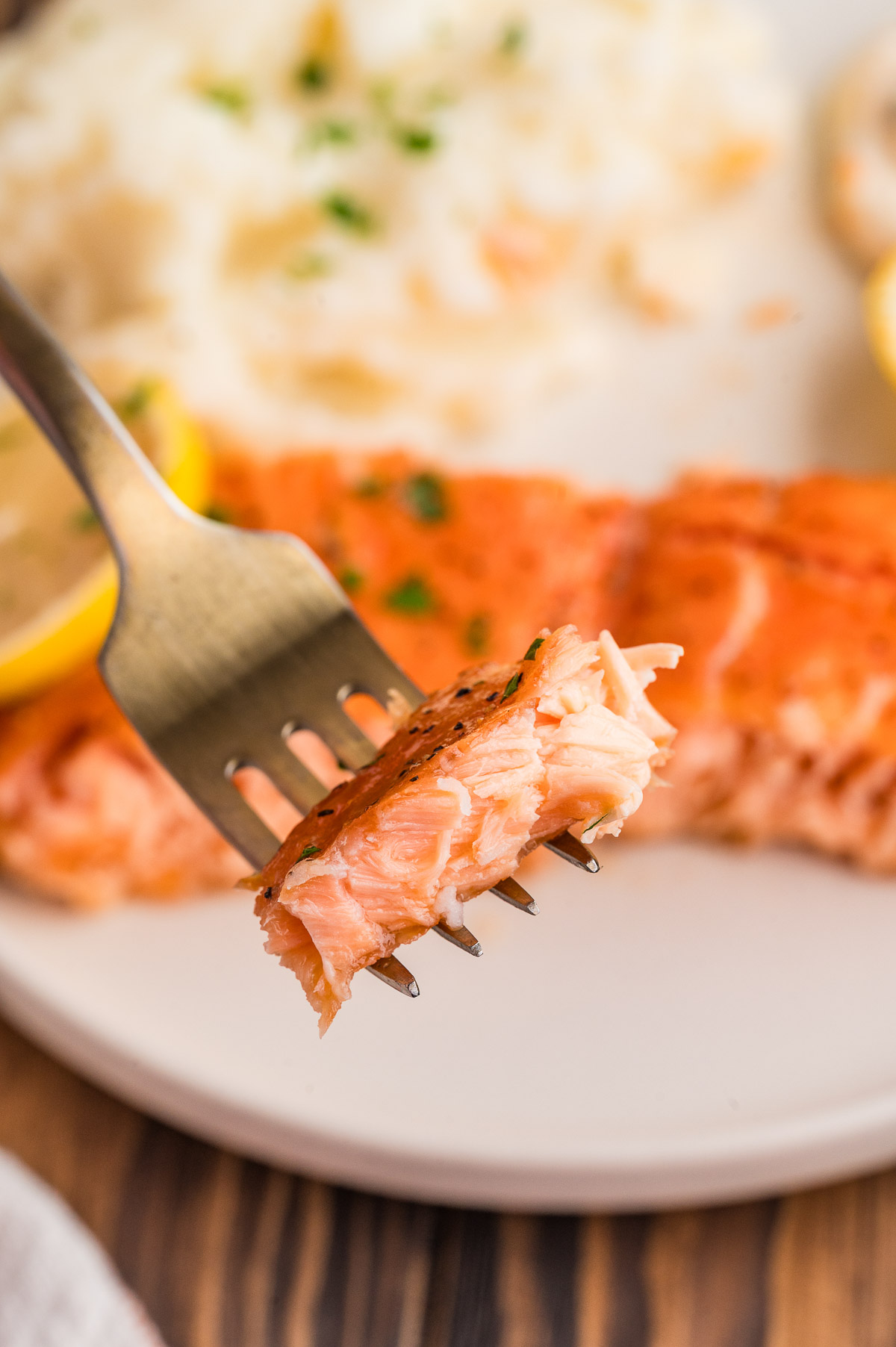 A fork holding up some salmon.