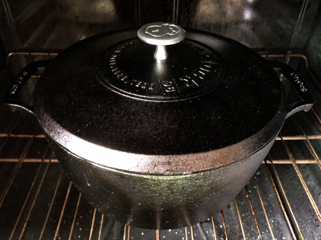 The lid has been placed on the Dutch oven and the roast has been put in the oven. 