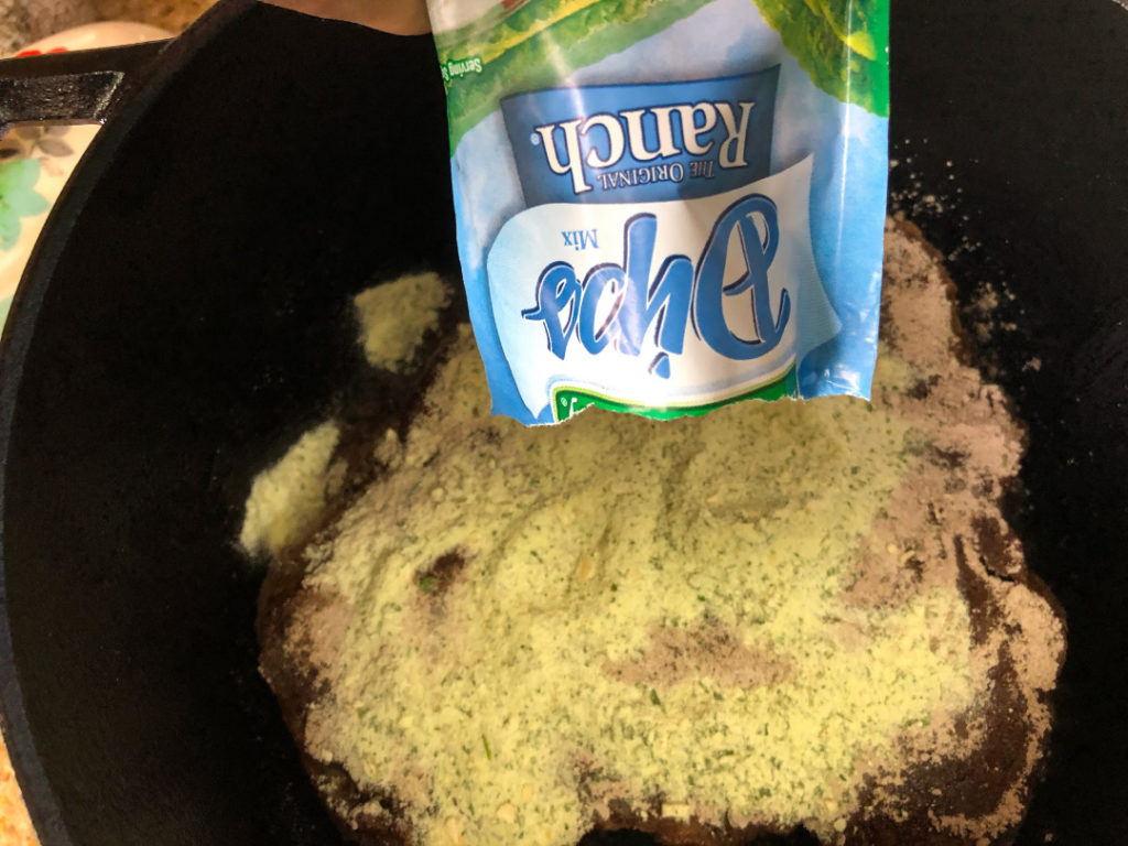 The packet of Ranch mix is being added atop the roast
