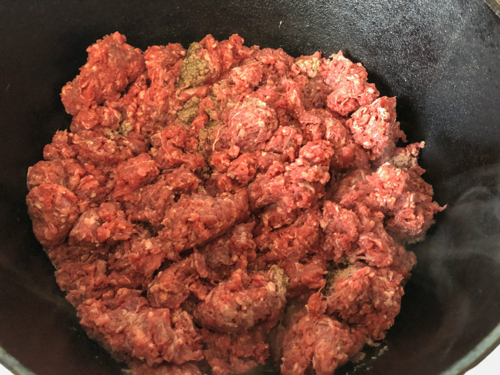 Lean ground beef crumbled into a hot dutch oven. 