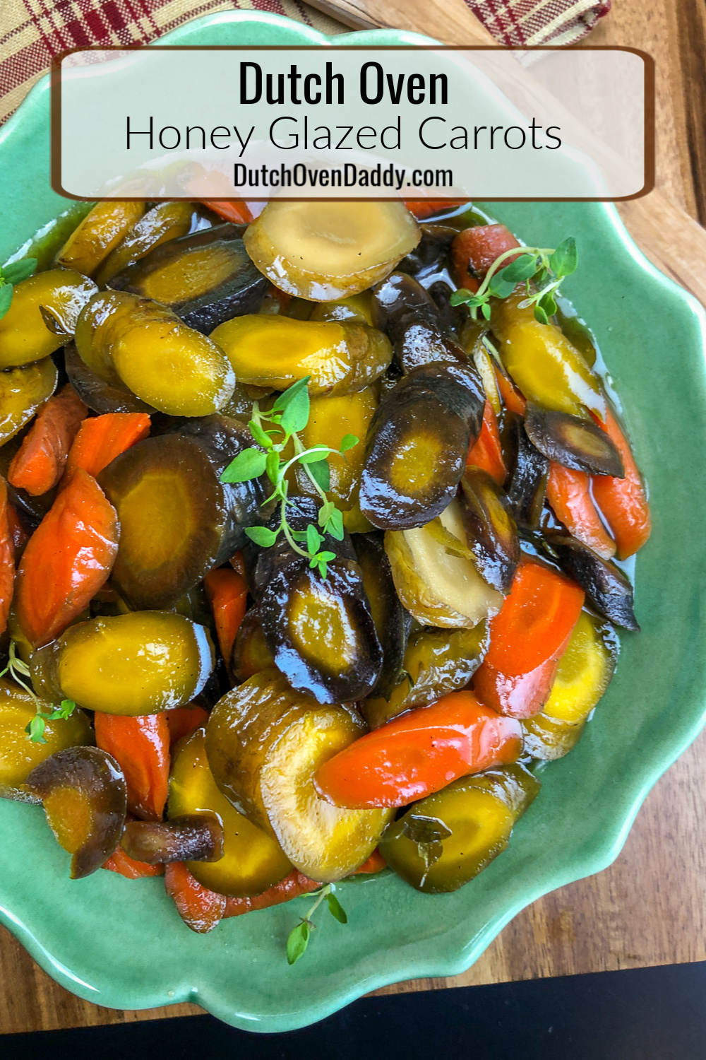 Quad-colored carrots in a thick honey glaze garnished with fresh time in a green bowl.