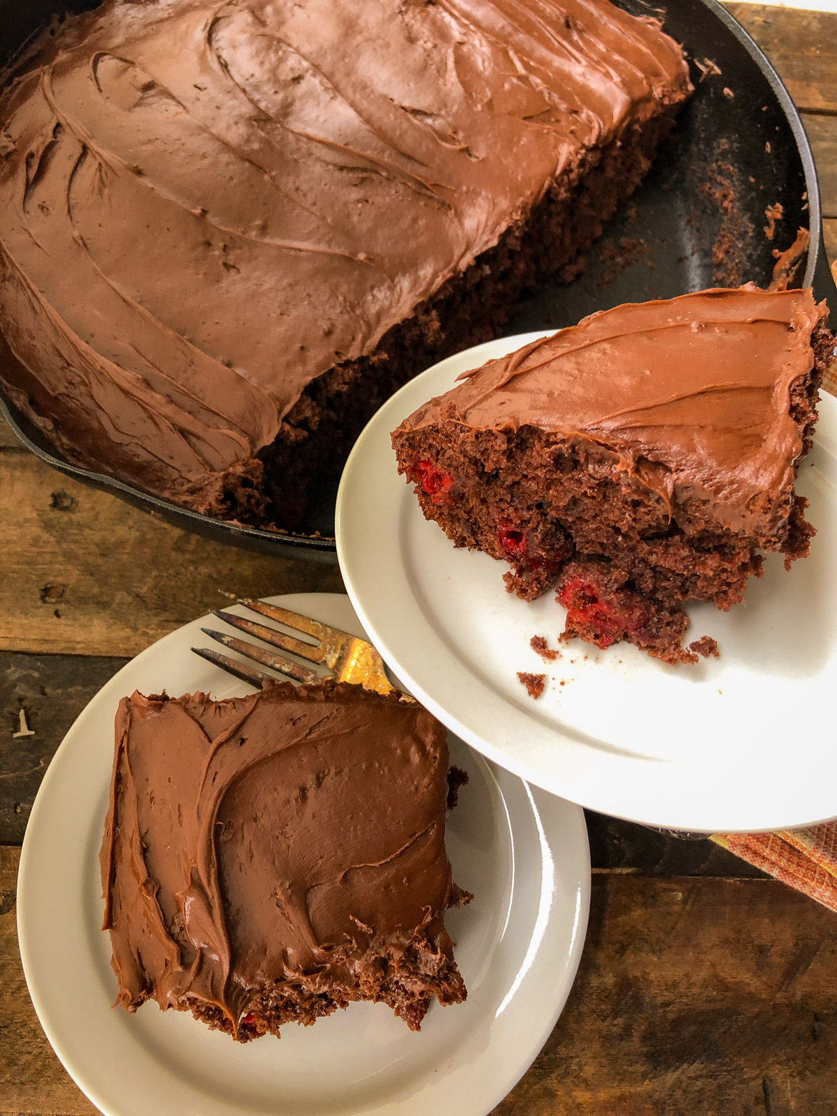 Sliced cherry chocolate cake showing moist crumb and whole cherries.