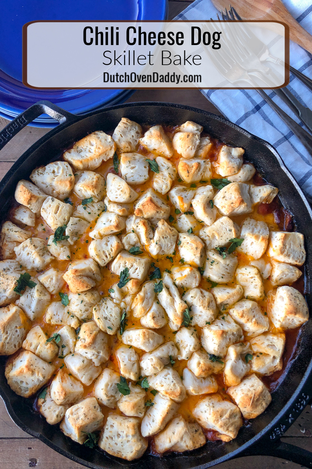 Baked cast iron skillet with chili, cheese and hotdogs, topped with a seasoned biscuit top.