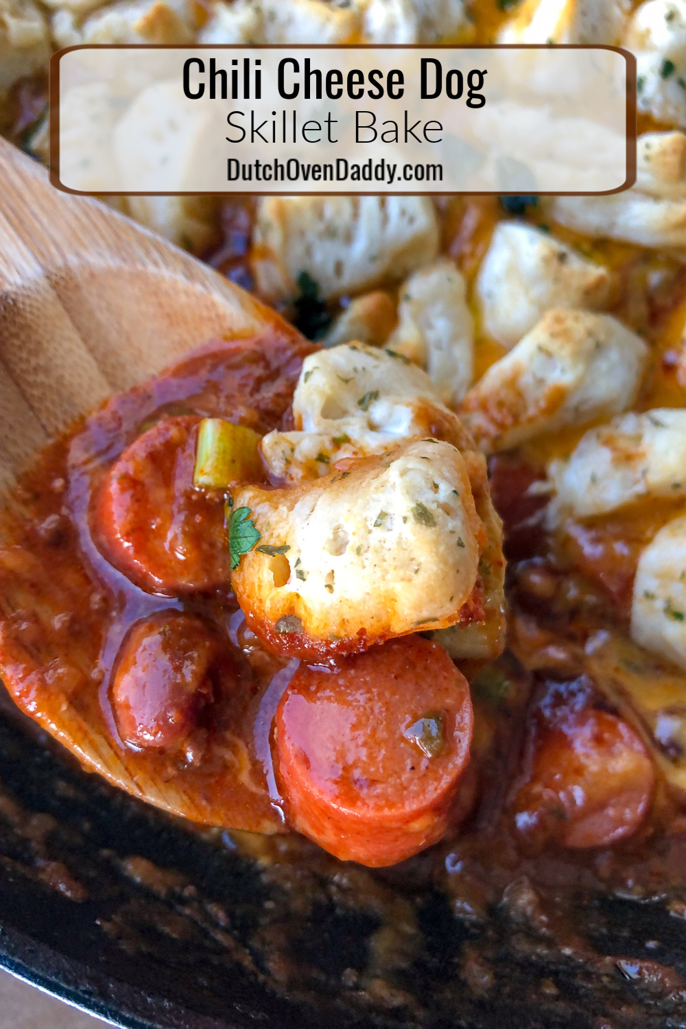 A scoop of hot dogs, chili, and garlic butter biscuits on a wooden spoon. 