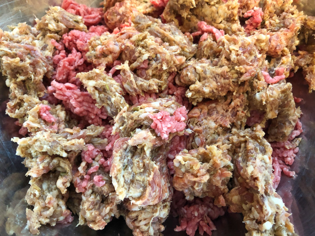 Ground beef and ground Italian sausage crumbled into a large bowl. 