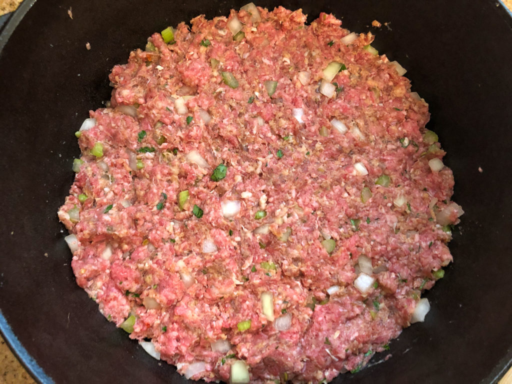 The meatloaf mixture patted down into a Dutch oven, ready for baking. 