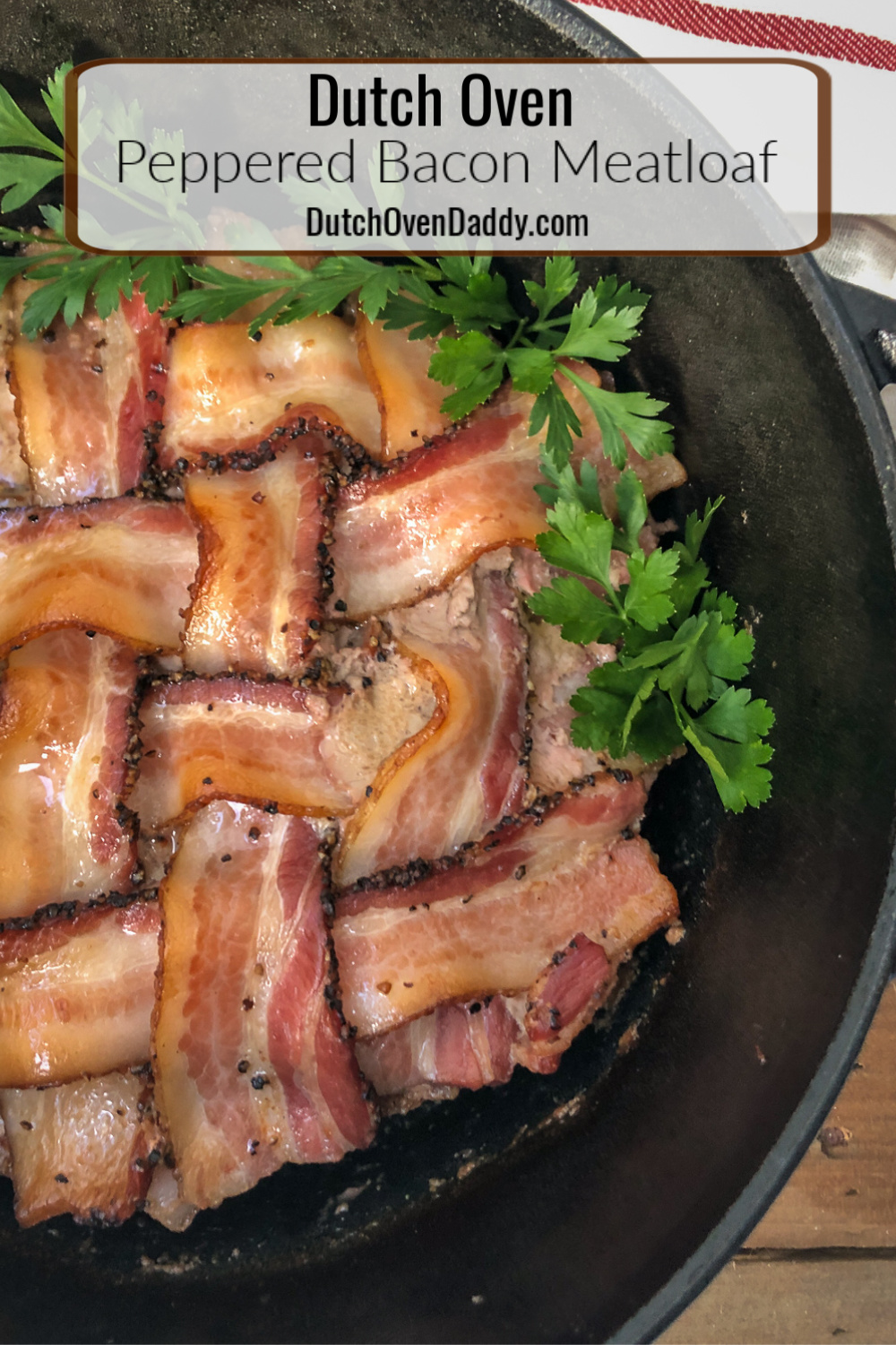 Peppered bacon latticed over a hearty meatloaf in a dutch oven garnished with fresh parsley. 