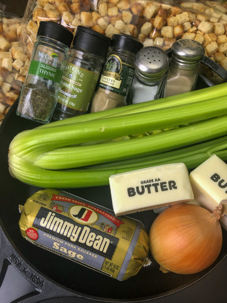 Ingredients needed to make the dressing: Sage Pork Sausage, onion, butter, celery, dried bread, herbs, and seasonings, all nestled in a cast iron skillet. 