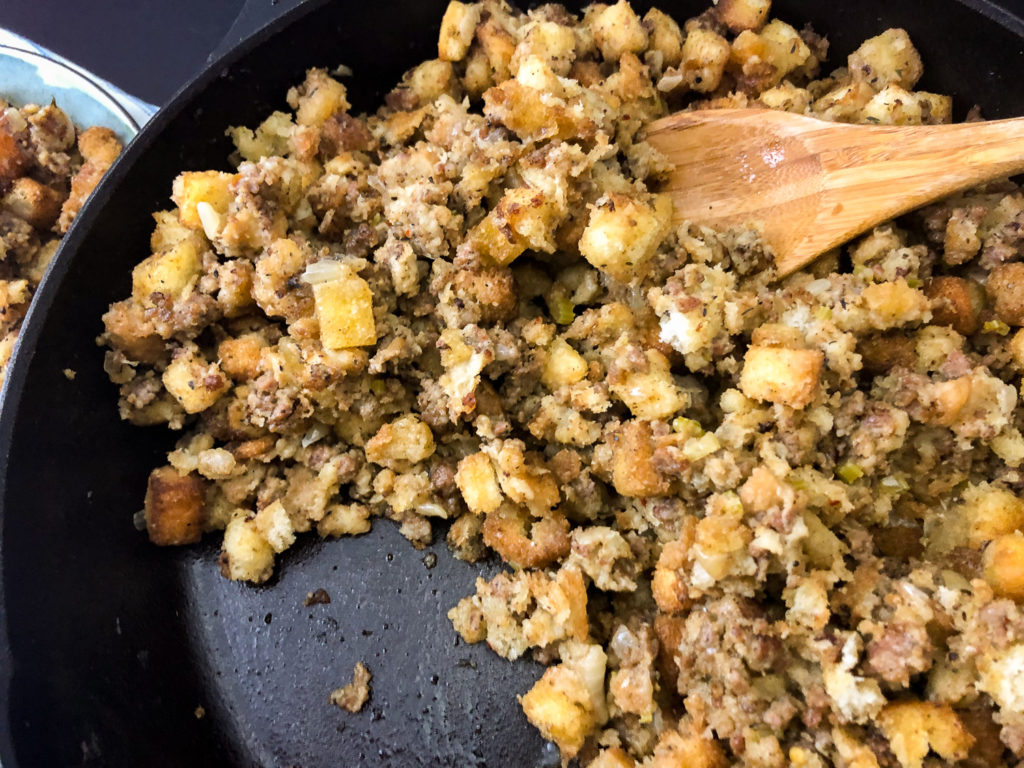 Horizontal image of the cooked sage sausage dressing in a cast iron skillet. 