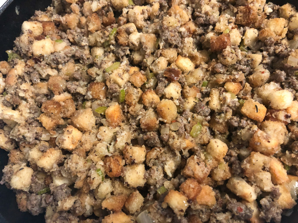 The fully assembled sage sausage stuffing is in the cast iron skillet, ready to be baked. 