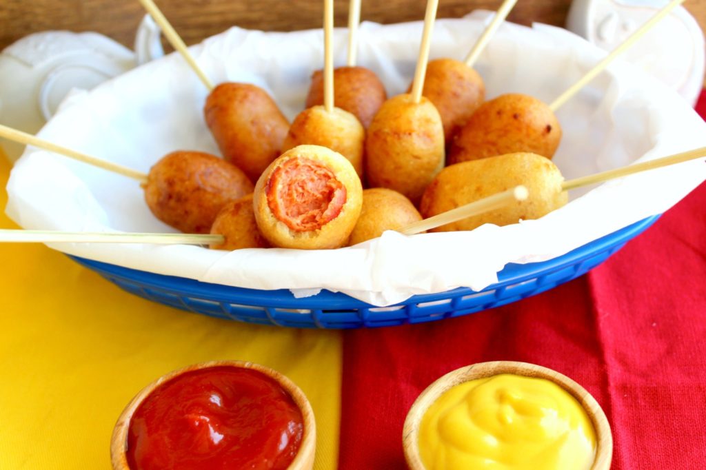 Mini Hotdogs in a basket with ketchup and mustard