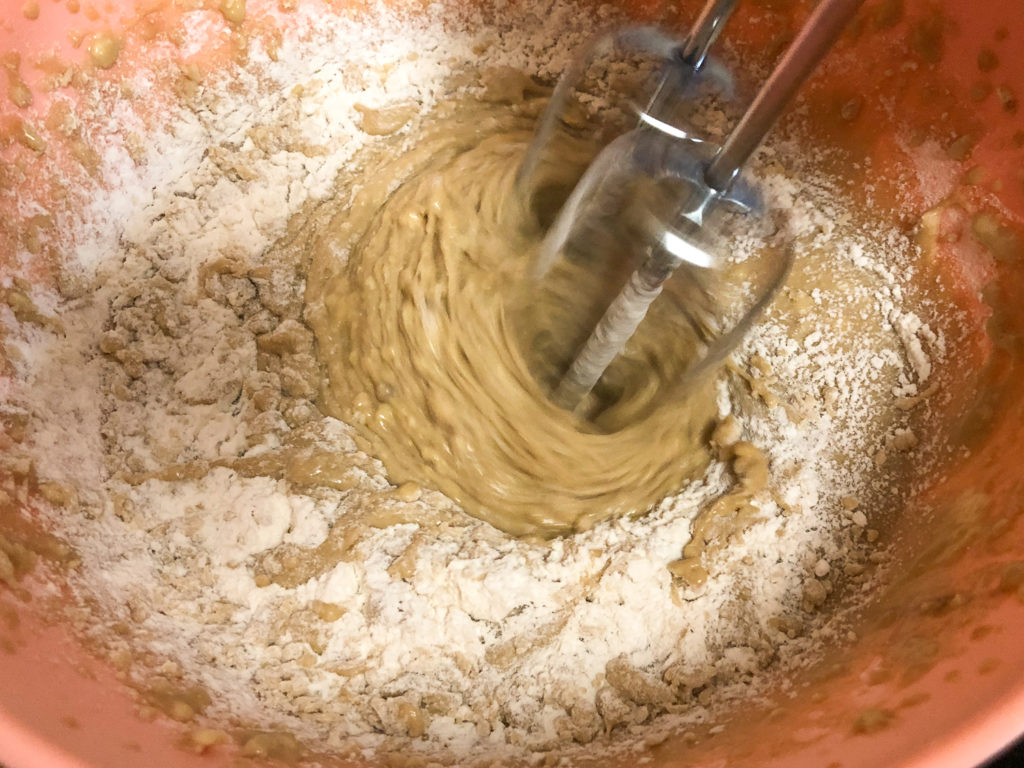 Apple cake batter coming together by a hand mixer. 