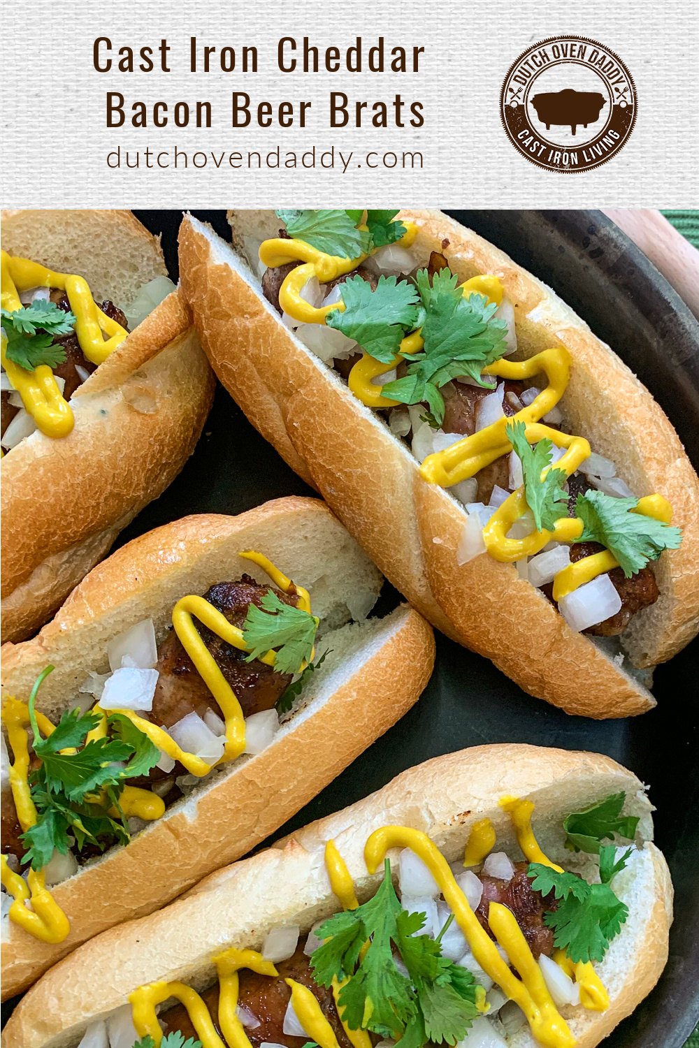 Branded image of four bratwursts in a bun topped with fresh onion, cilantro and mustard, resting in a cast iron skillet. 