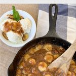 Branded image of bananas foster with some plated in a bowl.