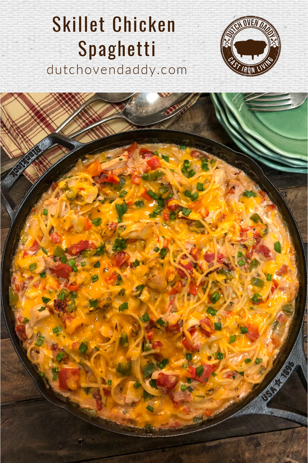 Chicken spaghetti in a cast iron skillet topped with cheese and green onions.