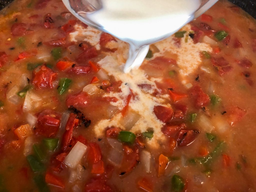 Half and Half being added to the skillet sauce for chicken spaghetti.