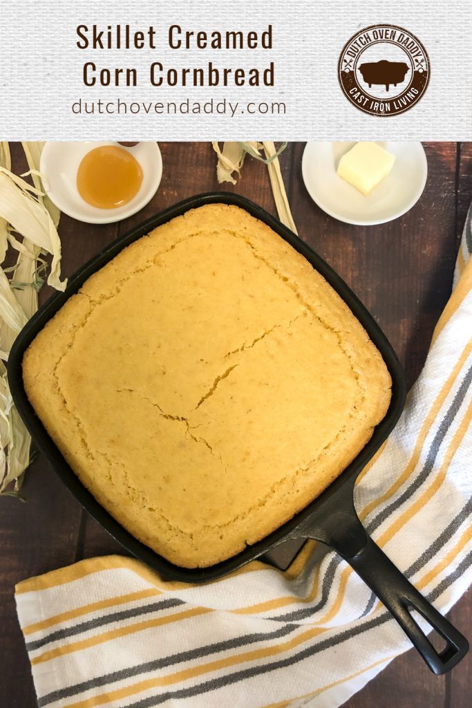 Branded image of creamed corn cornbread in a square cast iron skillet with honey and butter in the background. 