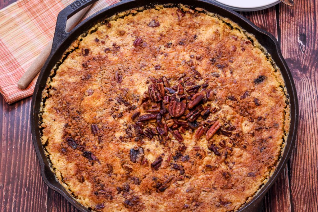 Close up image of baked pumpkin dump cake in a cast iron skillet. 