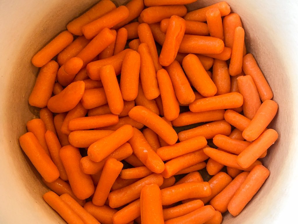 Baby carrots added to the bottom of an enameled Dutch oven.