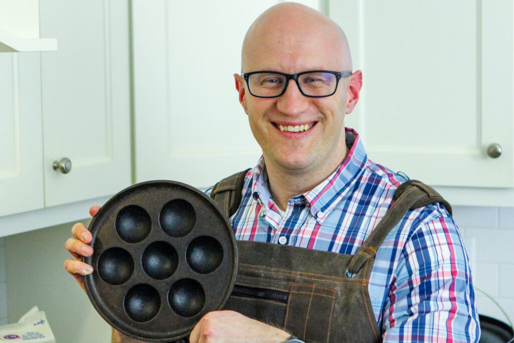 Ned of Dutch Oven Daddy showing a cast iron aebleskiver pan. 