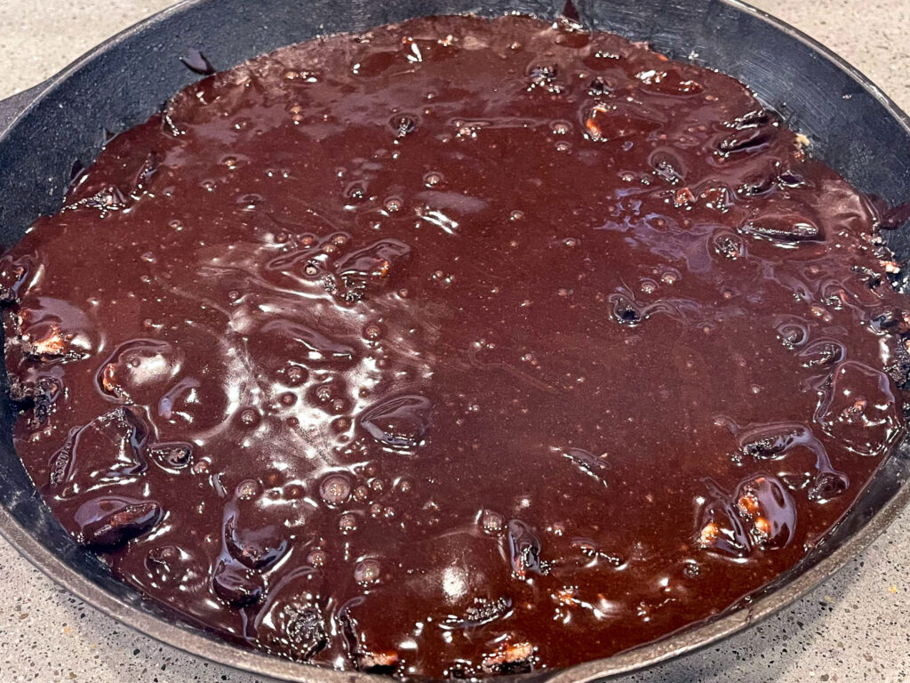 Chocolate fudge brownie mix poured over the bare metal skillet mixture.