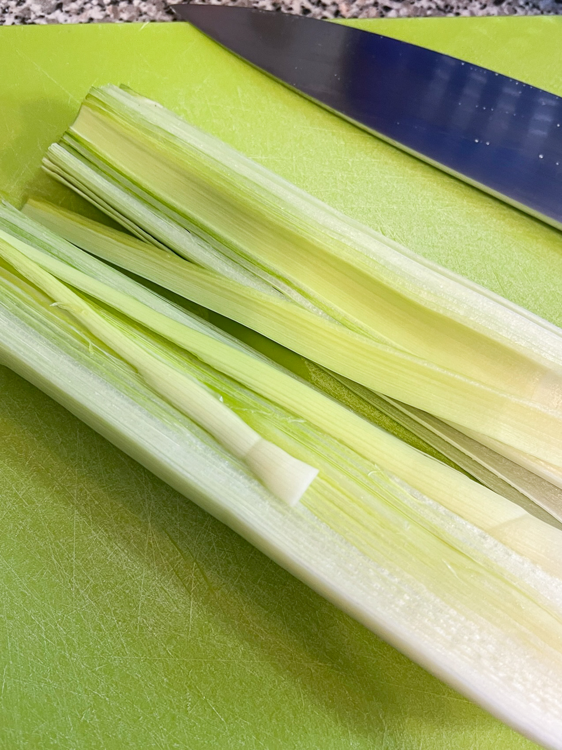 Leeks sliced in half and being cleaned.