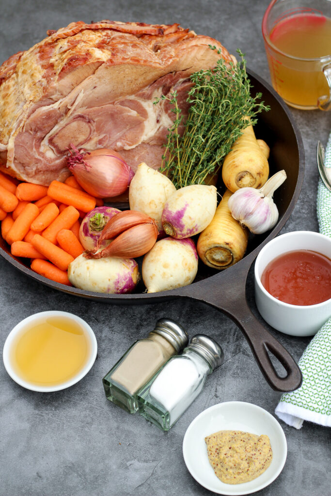 Recipe ingredients: ham, broth, garlic, parsnips, thyme, turnips, shallots, carrots, apple cider vinegar, salt, pepper, honey, and stone ground mustard.