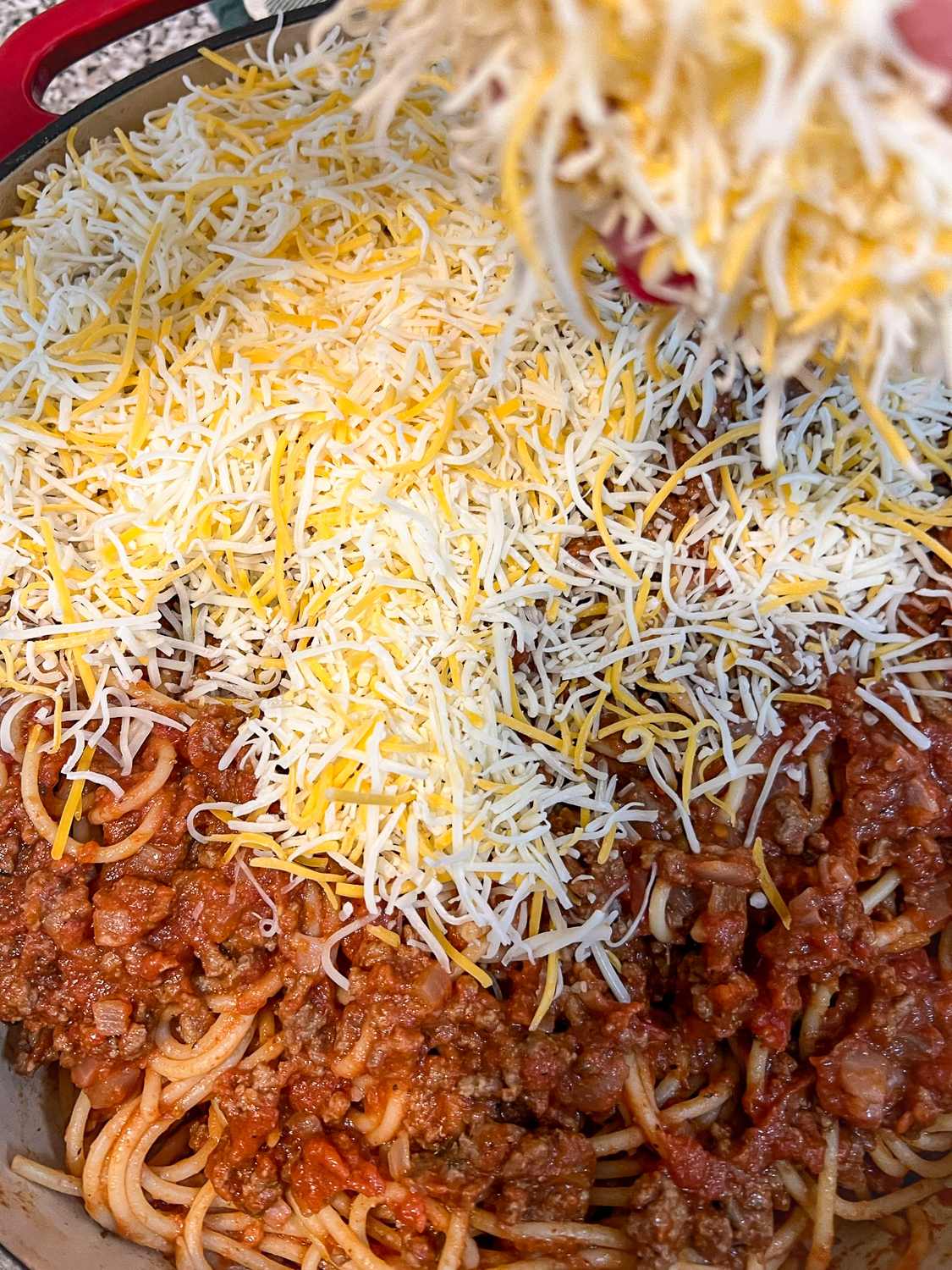 Cheese being added to the pasta dish.