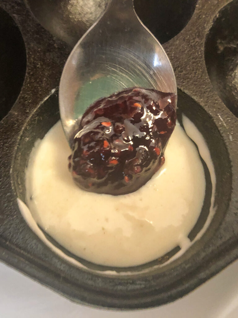 A dollop of raspberry jam being added to the aebelskiver batter.