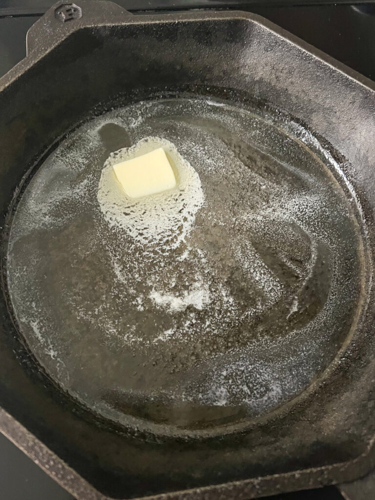 Butter melting in a cast iron skillet.