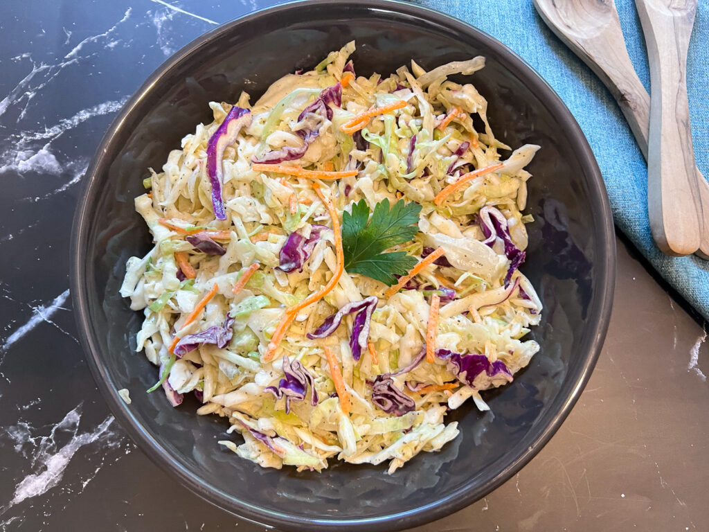 Prepared coleslaw in a black bowl.