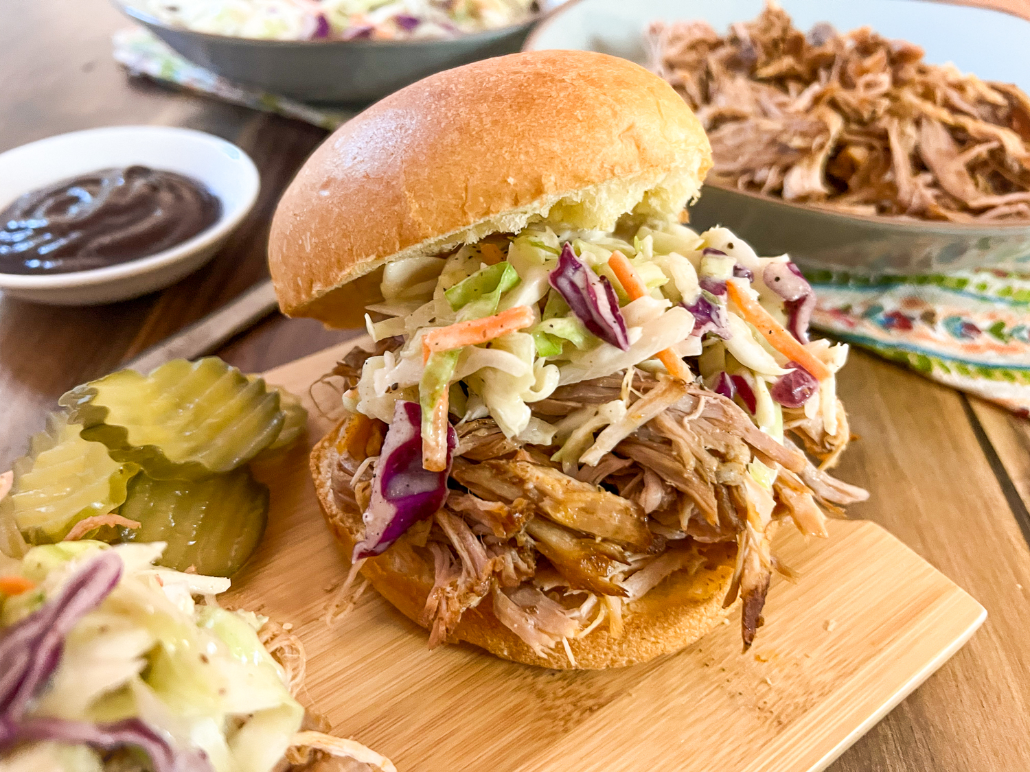 Smoked pulled pork in a bun topped with coleslaw.