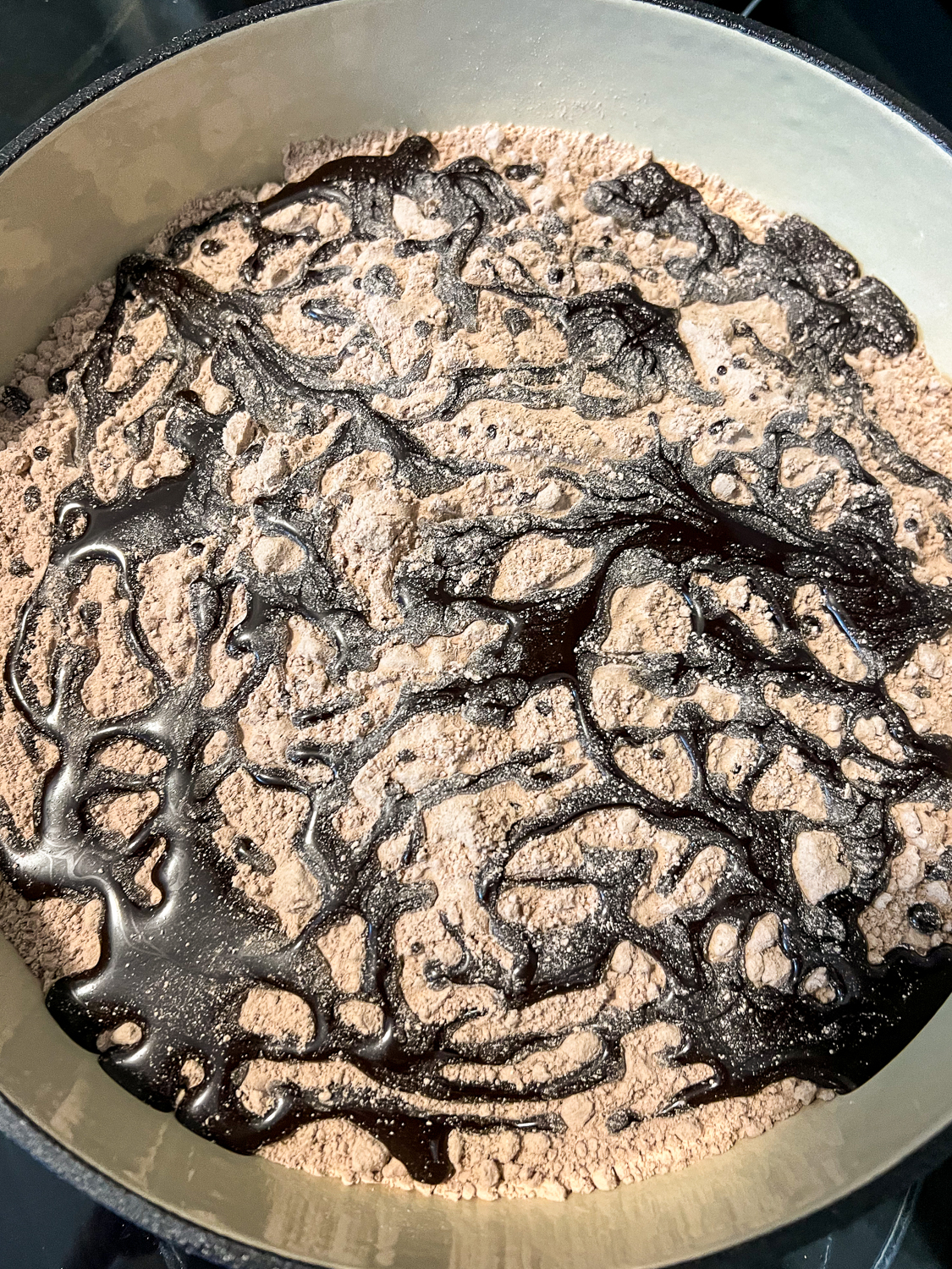 Chocolate syrup has been drizzled over the dry cake mix.