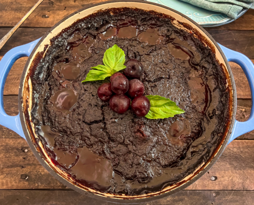 Cola Chocolate Cherry Dump Cake has cooled, garnished with fresh cherries and mint, and is ready to be served.