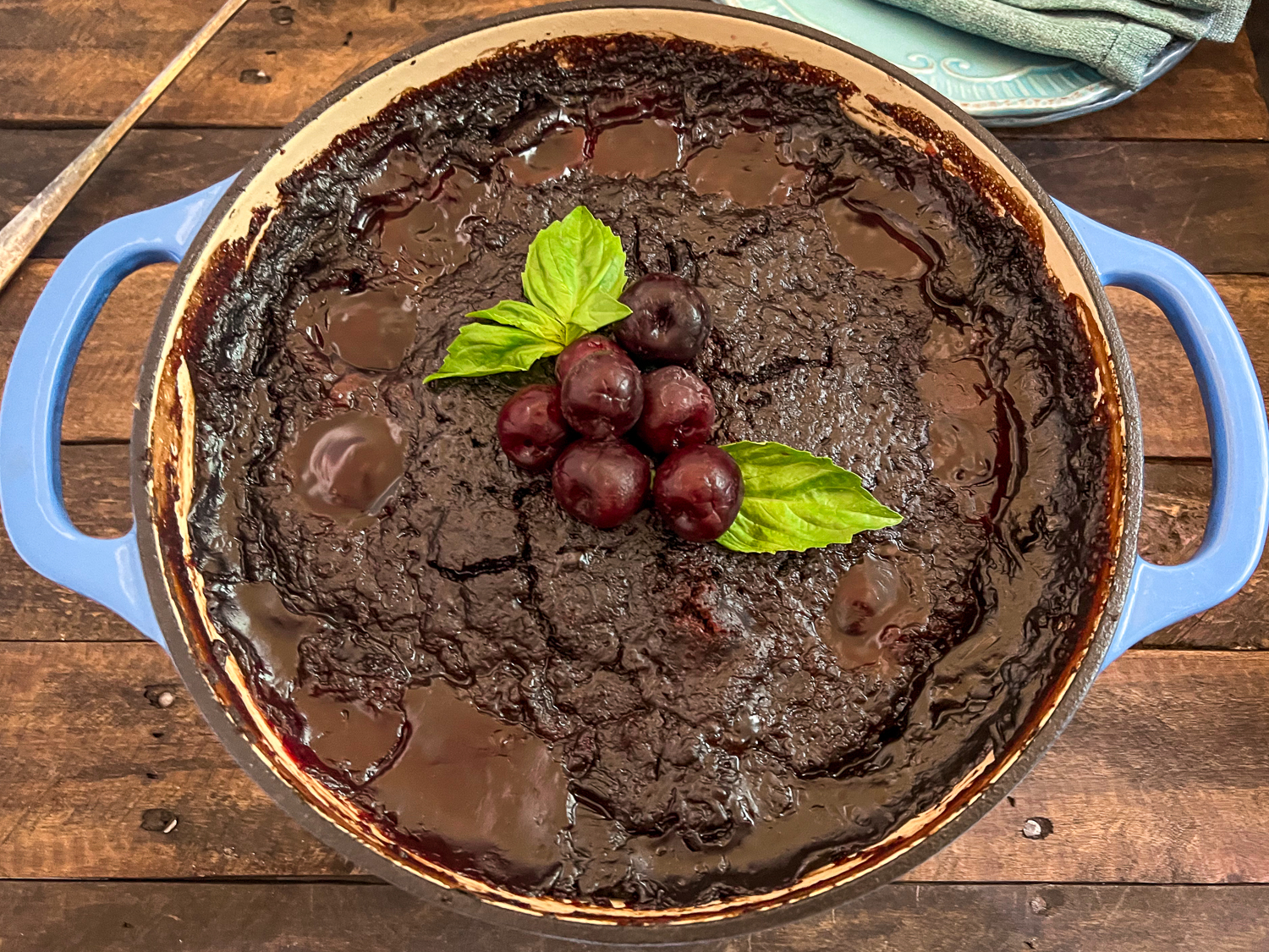 Cola Chocolate Cherry Dump Cake has cooled, garnished with fresh cherries and mint, and is ready to be served.
