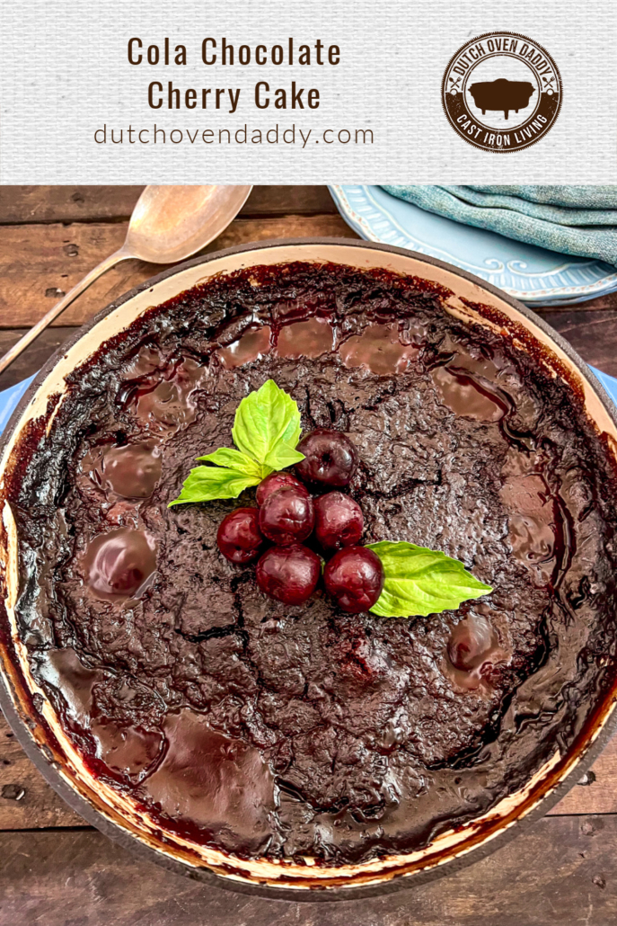 Branded image of Cola Chocolate Cherry Cake in a dutch oven garnished with fresh cherries and mint leaves.