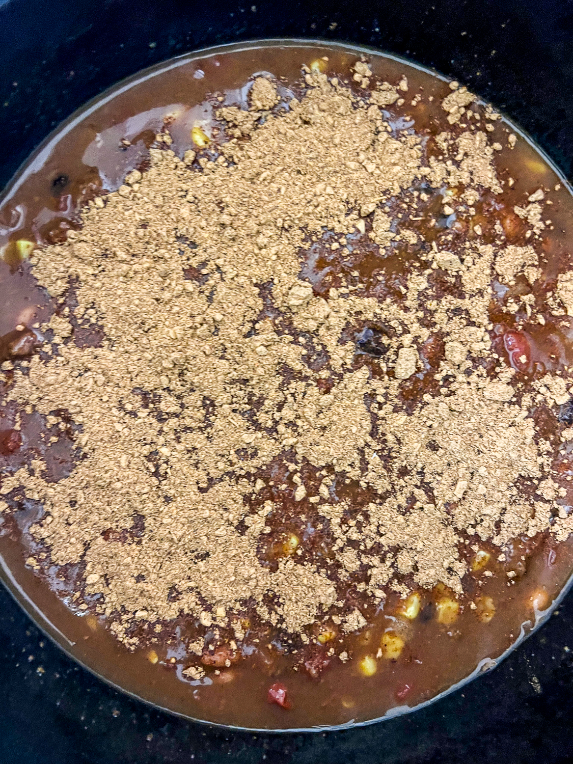 Taco seasoning packet added to the canned food in the pot.