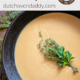 Branded Image of Turkey Gravy in a cast iron skillet with a boquest of herbs as a garnish.