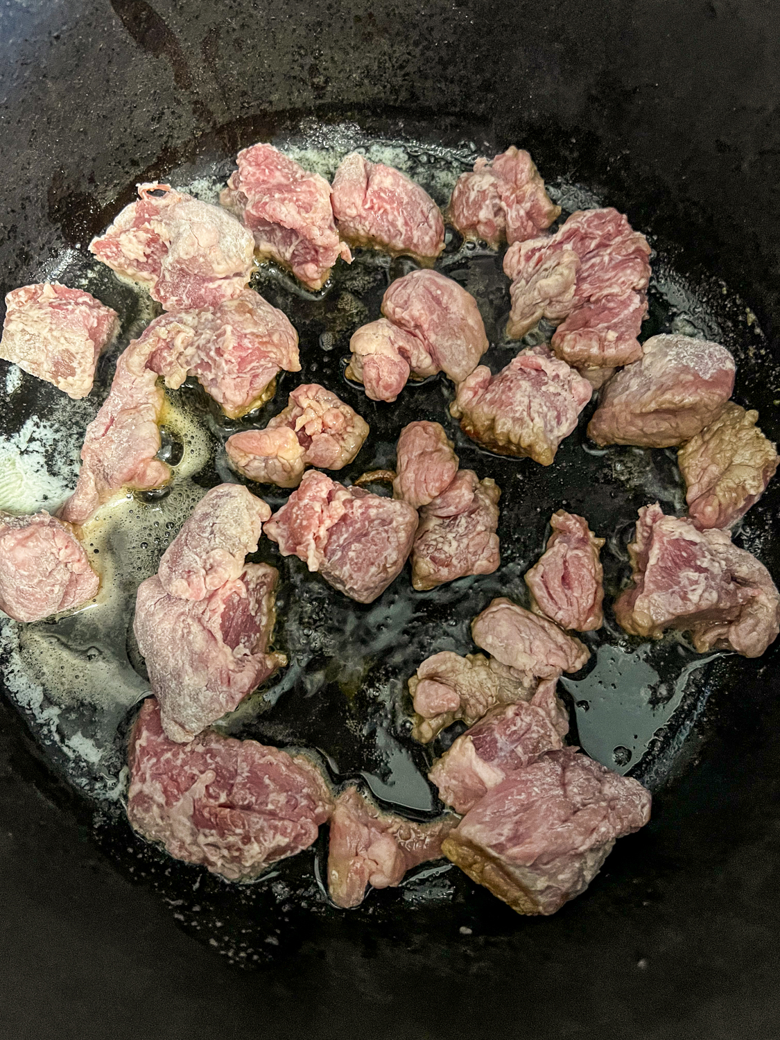 Beef searing in oil and butter in the dutch oven.