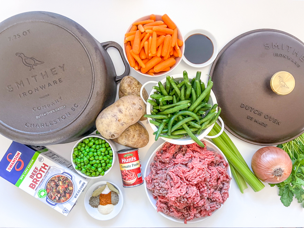 Ingredients to make ground beef stew in a Dutch oven.