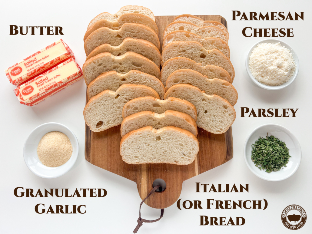 Ingredients to make garlic bread in cast iron: bread, butter, parmesan cheese, parsley, and granulated garlic.