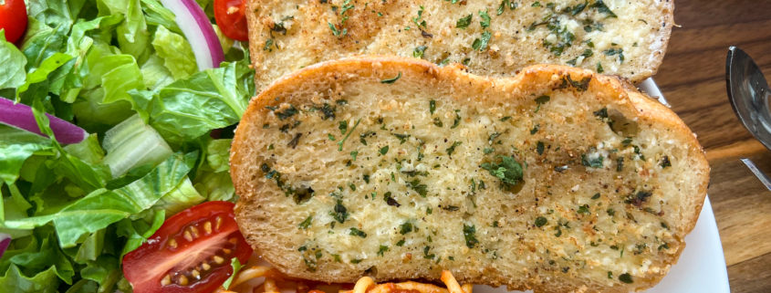 Two toasted slices of garlic bread close up.