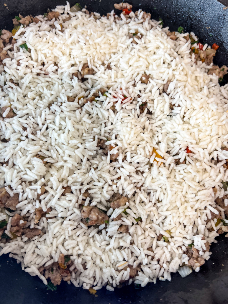 Uncooked Minute-brand rice has been added to the skillet.