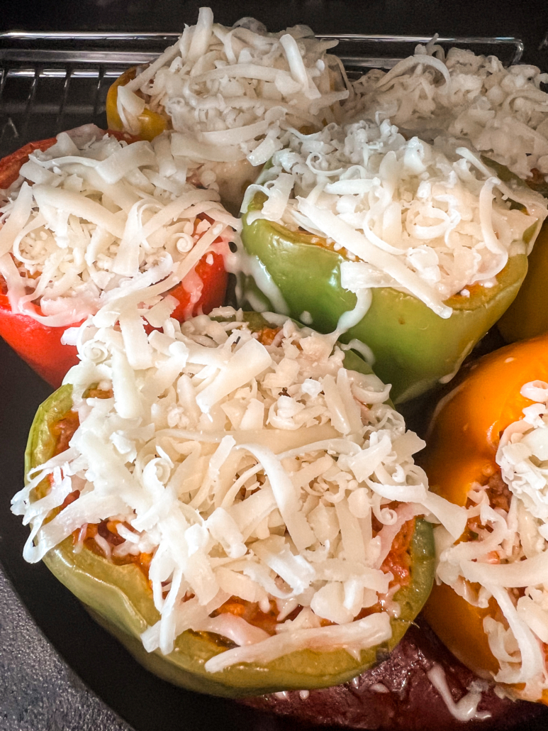 Grated cheese tops the nearly cooked bell peppers.