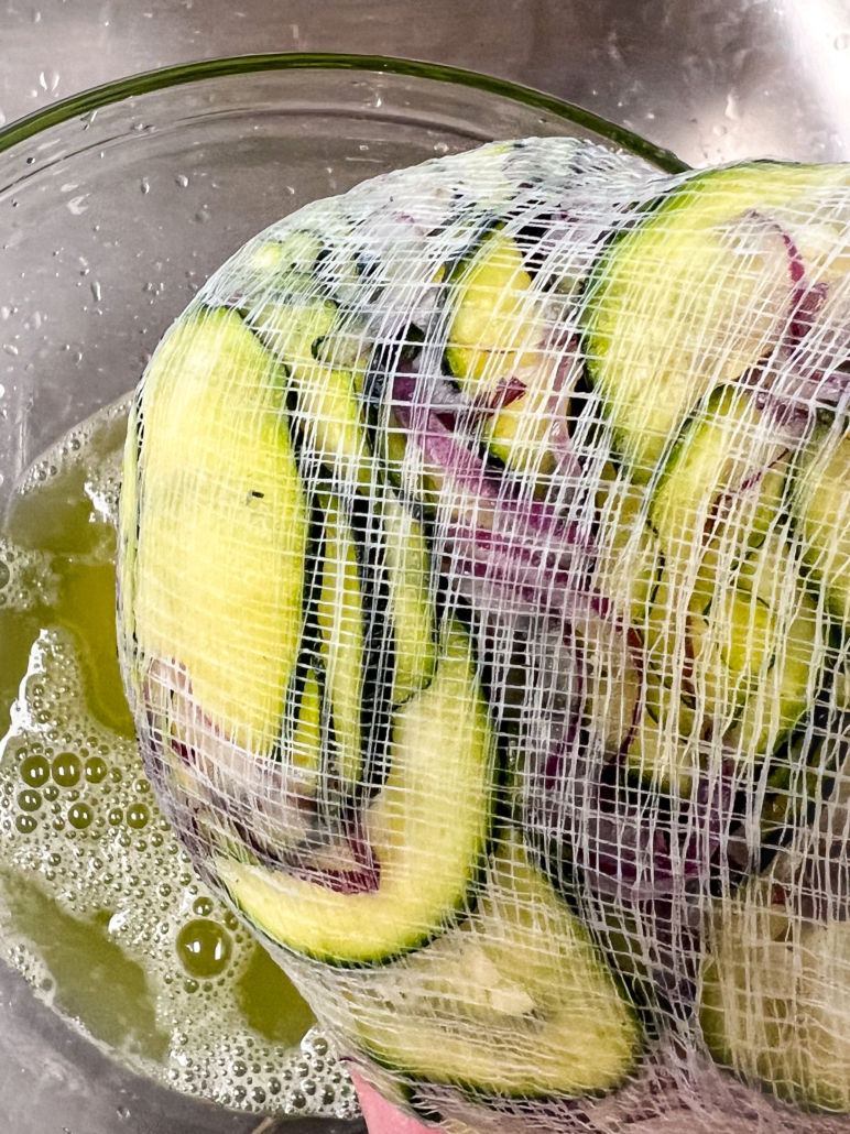 Zucchini and red onion being pressed through cheesecloth.