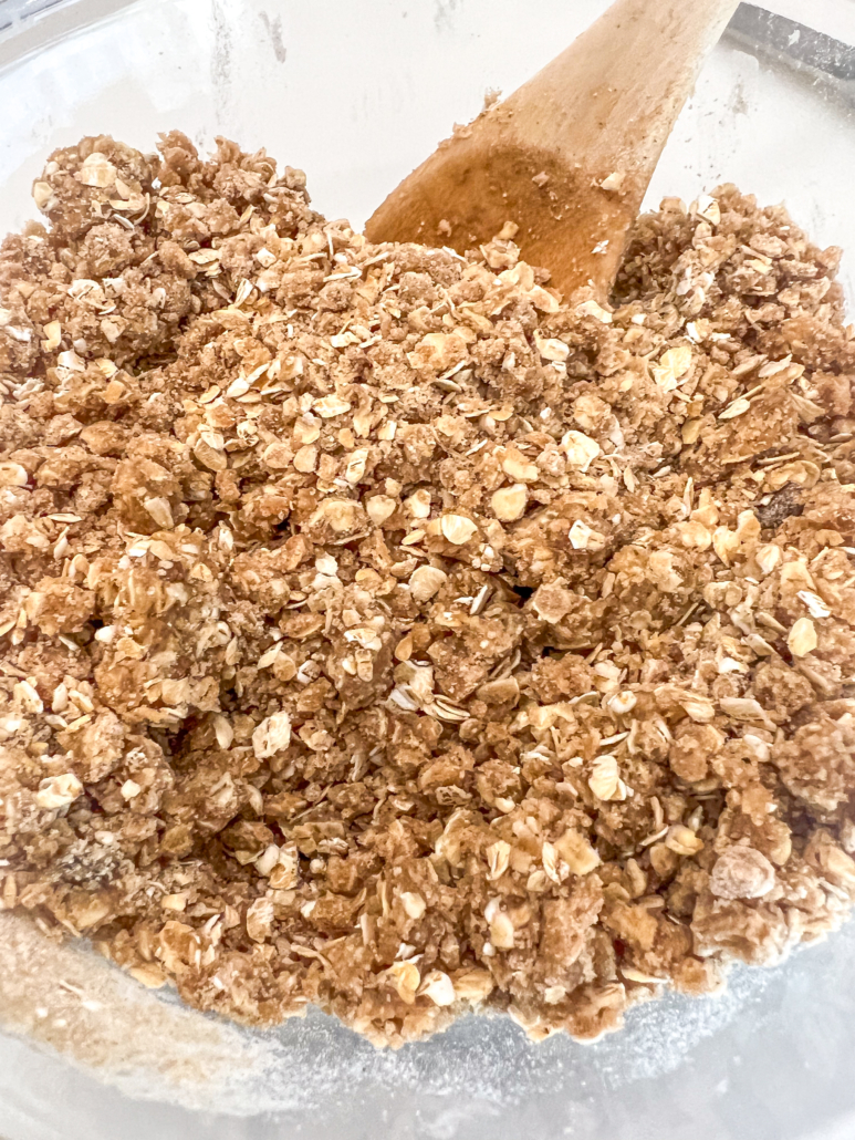 Melted butter has been mixed into the oat mixture to form the topping for the apple crisp.