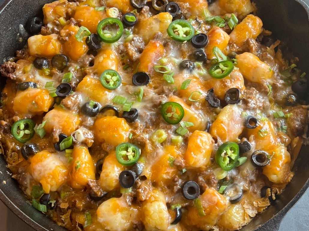 Freshly baked totchos garnished with green onions and sliced jalapenos.